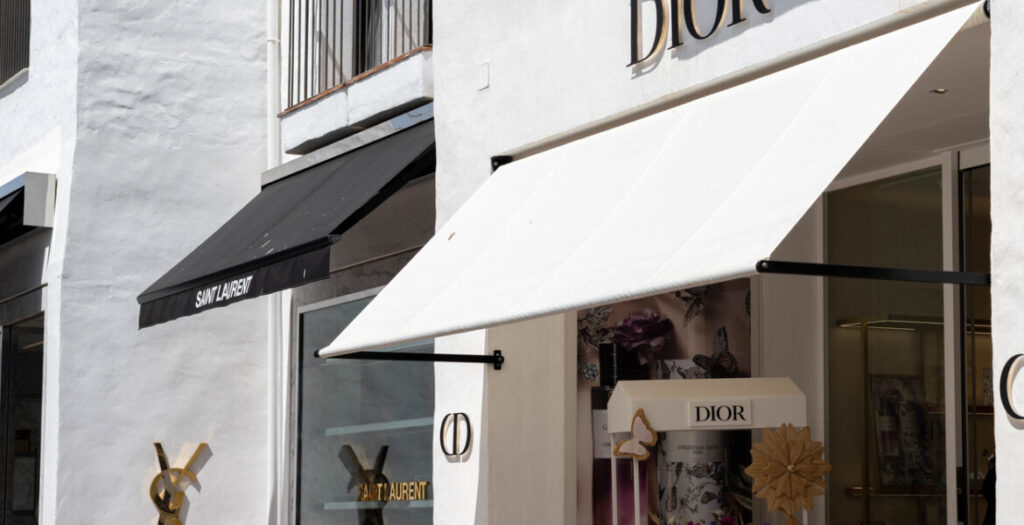Dior and Saint Laurent luxury boutiques with white and black awnings.